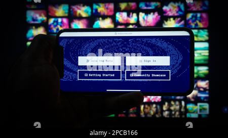 Mobile phone with Midjourney website artificial intelligence program on screen in front of a gallery homepage. Stock Photo