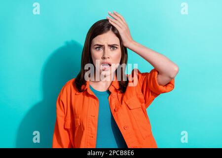 Photo of worried nervous lady wear orange clothes arm head impressed reaction bad news bankruptcy isolated on cyan color background Stock Photo