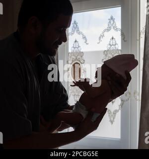 A Happy Father holding his Newborn baby girl Stock Photo