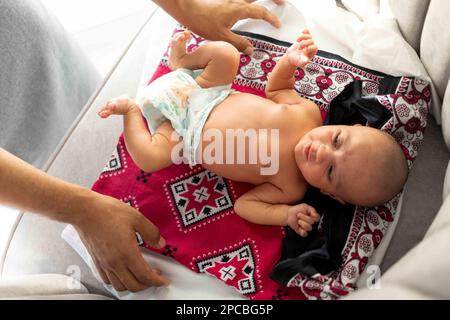 Natural Phototherapy. A Baby laying without clothes near a window to get morning sunlight on her skin to reduce her Newborn jaundice Stock Photo