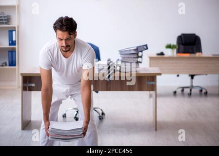 Young businessman employee doing sport exercises at workplace Stock Photo