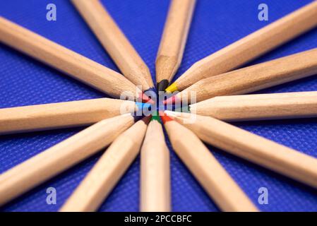 Multi-colored pencils on a blue background. Learning and creativity concept Stock Photo