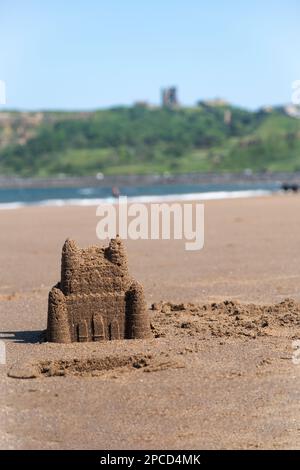 Sandcastle on Scarborough north beach with Scarborough castle in the background Stock Photo