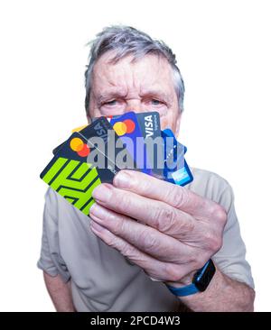 Morgantown, WV - 13 March 2023: Senior adult man holding stack of credit cards to illustrate debt and overspending Stock Photo
