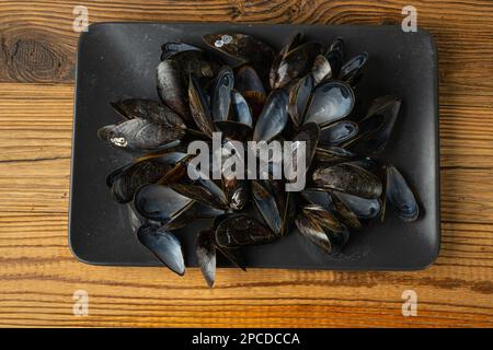 Empty Mussels Shell, Black Clams Shells, Eaten Mollusc, Empty Shellfishes, Seafood Leftovers Mussel on Wood Background Top View Stock Photo