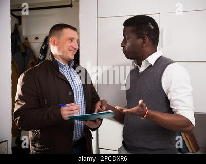 Smiling man participating in survey at home Stock Photo