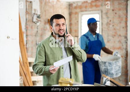 Man architect having telephone conversation about project documentation Stock Photo