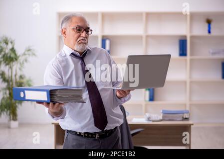 Old employee doing sport exercises during break Stock Photo