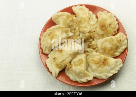 Delicious and freshly prepared dumplings on a plate. Dumplings with fried qibuli, close-up Stock Photo