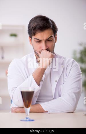 Young chemist examining soft drink at the lab Stock Photo