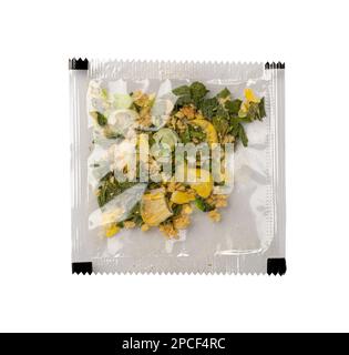 Small Spice Pouch Isolated, Dried Vegetables and Herbs Mix in Plastic Bag, Dry Peas, Greens, Dehydrated Food Pieces on White Background Stock Photo