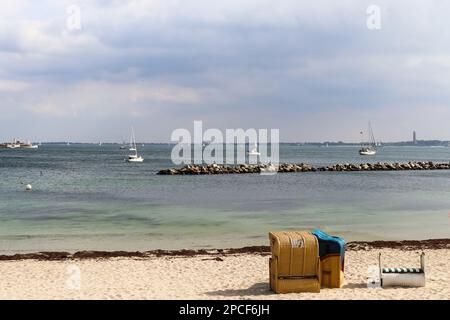 Many sailboats on a sandy beach in Germany with some beach chairs Stock Photo
