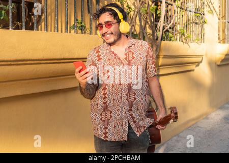 Portrait Of Young Latin Man Listening Music In The Street Stock Photo
