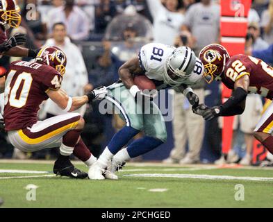 Dallas Cowboys wide receiver Terrell Owens (81) is tackled for a 2-yard  loss in the first quarter by Washington Redskins safety Adam Archuleta (40)  and cornerback Carlos Rogers (22) in an NFL