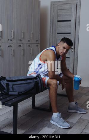Handsome man with shaker in locker room Stock Photo
