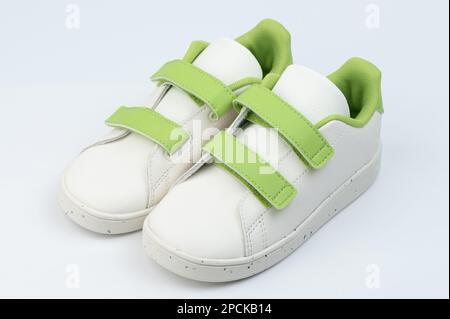 White with green velcro pair shoes isolated on studio background Stock Photo