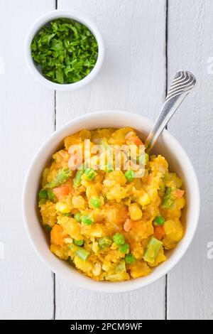 Charquican, a traditional Chilean dish, vegetarian version, made of lightly mashed and mixed potatoes, pumpkin, onion, carrots, peas, corn and beans Stock Photo