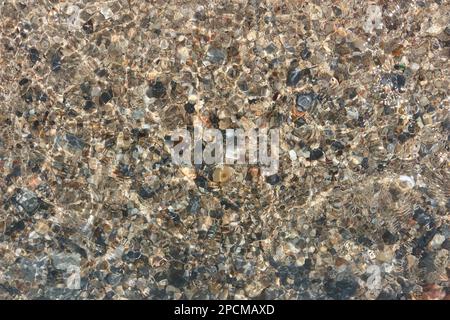 The water surface is so clear that you can see through and see the rocks below. Stock Photo