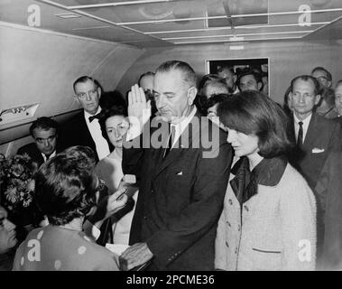 1963 , 22 november, Dallas , Texas, USA : The american U.S.  president Lyndon Baines  Johnson ( 1908 - 1973 )taking the oath of office on Air Force One following the assassination of John F. Kennedy  . Left to right: Mac Kilduff (holding dictating machine), Judge Sarah T. Hughes , Jack Valenti , Congressman Albert Thomas, Marie Fehmer (behind Thomas), First Lady Lady Bird Johnson, Dallas Police Chief Jesse Curry, President Lyndon B. Johnson, Evelyn Lincoln (eyeglasses only visible above LBJ's shoulder), Congressman Homer Thornberry (in shadow, partially obscured by LBJ), Roy Kellerman (partial Stock Photo