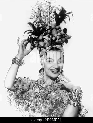 1940 ca : The exotic brazilian actress CARMEN MIRANDA ( 1909 - 1955 ),  pubblicity still - MOVIE - FILM - CINEMA - portrait - ritratto -  CINEMA - FILM - hat - cappello - bijoux - jewels - gioiello - gioielli - smile - sorriso - bracelets - bracciale - bracciali - braccialetto - SMILE - SORRISO - turban - turbante - SAMBA - frutta finta - fake fruits © Archivio GBB / Stock Photo