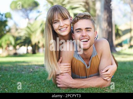 Relaxing in the park. Portrait of a happy young couple lying in the park. Stock Photo