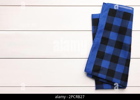 Folded blue checkered bandana on white wooden table, top view. Space for text Stock Photo