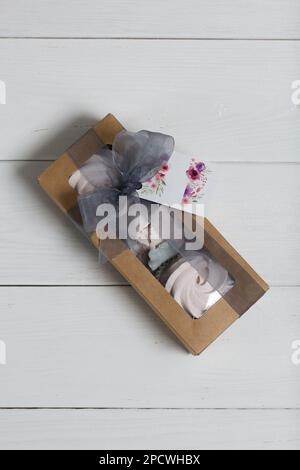 Homemade marshmallows in a cardboard box. Zephyr flowers. Box with transparent lid. Gift wrap. Tied with ribbon. Stock Photo