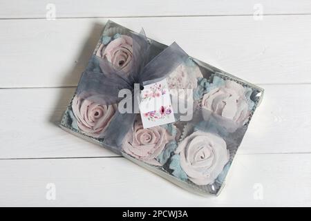 Homemade marshmallows in a cardboard box. Zephyr flowers. Box with transparent lid. Gift wrap. Tied with ribbon. Stock Photo