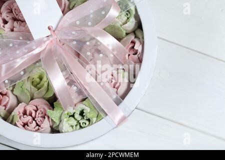 Homemade marshmallows in a cardboard box. Zephyr flowers. Box with transparent lid. Gift wrap. Tied with ribbon. Stock Photo