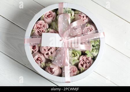Homemade marshmallows in a cardboard box. Zephyr flowers. Box with transparent lid. Gift wrap. Tied with ribbon. Stock Photo