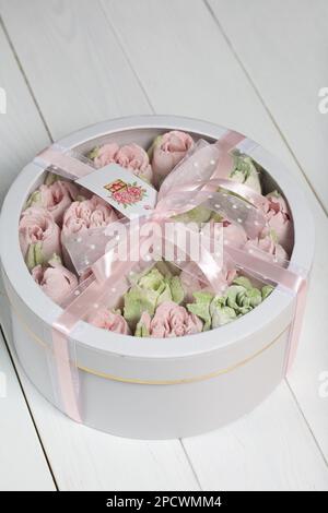 Homemade marshmallows in a cardboard box. Zephyr flowers. Box with transparent lid. Gift wrap. Tied with ribbon. Stock Photo