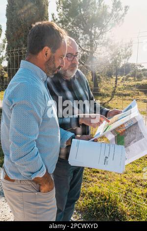 two men standing next to each other looking at documents. Teamwork concept Stock Photo