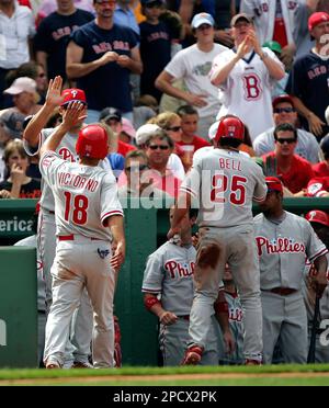 The Philadelphia Phillies' Shane Victorino (18) is safe at first as New  York Yankees first baseman Jason Giambi leaps but can't catch an overthrow  by second baseman Robinson Cano in the fourth