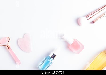 Beauty and self care flat lay with copy space. Face care, nail care and makeup accessories arranged on white background, top view. Stock Photo