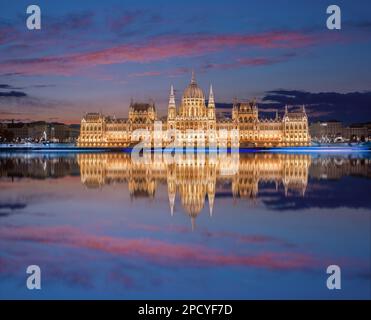 view on Parliament building in Budapest with fantastic perfect sky and reflection in water at dusk. calm Danube river. Popular Travel destinations. Stock Photo