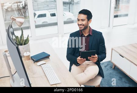 Office, Indian man at desk with tablet and smile at computer, reading good news email or successful sales report online. Business, smile and Stock Photo