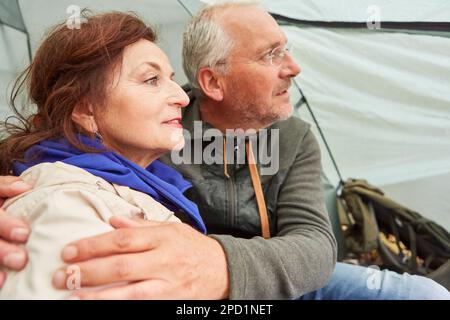 Contemplative senior couple spending leisure time while sitting in camping tent during vacation Stock Photo