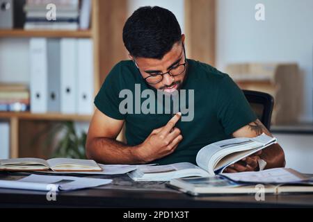 Student, black man and books to study on home desk thinking, reading and studying for college. Person learning and focused on information on page for Stock Photo