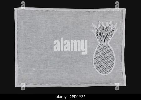 Northeast Brazilian Renaissance lace placemat, with an embroidered pineapple, isolated on black background. Stock Photo