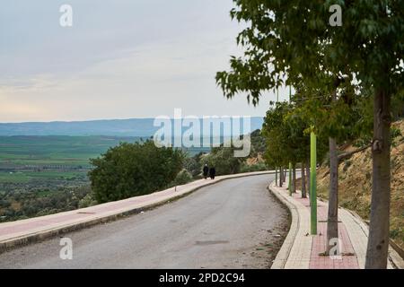 Man walking on a sidewalk in a Moroccan old mountain town Stock Photo
