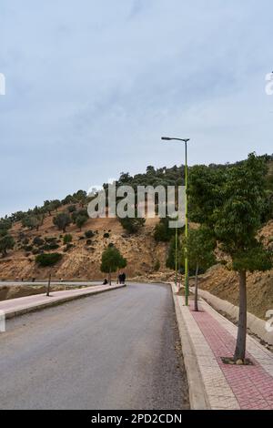 Man walking on a sidewalk in a Moroccan old mountain town Stock Photo