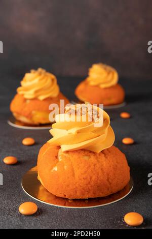 French cakes Chou of thin crispy choux pastry with a sweet shortcrust crust, mango and custard on gray background Stock Photo