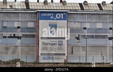 Eisenach, Germany. 14th Mar, 2023. The industrial monument 'O1', formerly the main plant of BMW car production, on the site of the former Eisenach car plant, has a building tarp on its facade. The city is planning to build a multifunctional hall in the building, which has been vacant for more than 20 years and will be used primarily as a sports facility for school, competitive and club sports. Credit: Martin Schutt/dpa/Alamy Live News Stock Photo