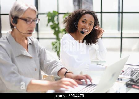 Young friendly operator woman agent with headsets working in a call centre. Stock Photo