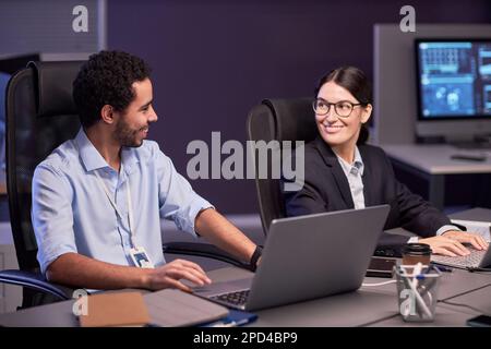 Portrait of two smiling business people discussing project at meeting in high tech office Stock Photo