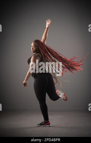 expressive woman with long braids dancing in the city very happy Stock ...