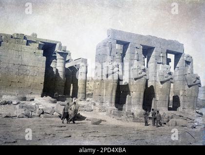 circa 1940s, historical, couple walking at the ancient ruins, Temple of Karnak, Luxor, Egypt. Local males in fez hats. Stock Photo