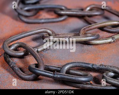 Old rusty link chain on an orange grunge background Stock Photo