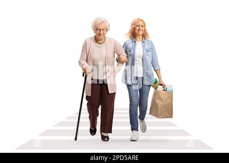 Woman helping an elderly lady with shopping bags on a pedestrian crossing isolated on white background Stock Photo