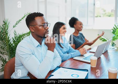 Serious Black businessman concentrates during boardroom meeting in office Stock Photo